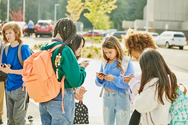 Crianças interagindo com seus celulares