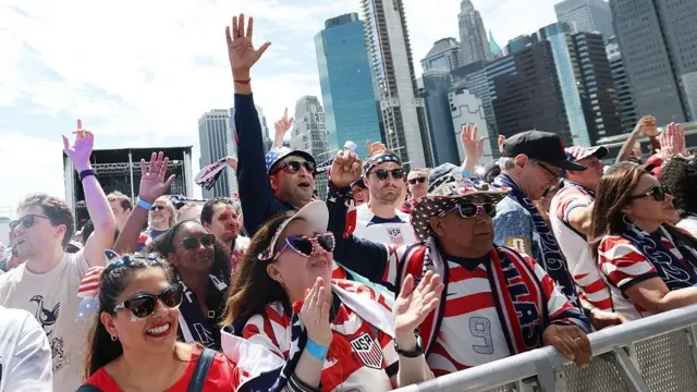 Um grupo de fãs americanos aplaude nas ruas da cidade de Nova York