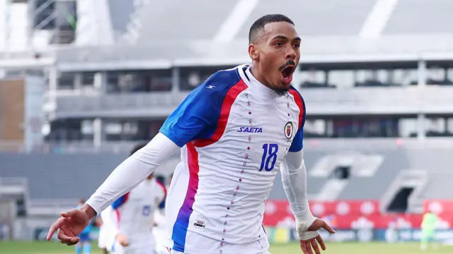 Wilson Isidor comemorando com uma camisa branca do Haiti.